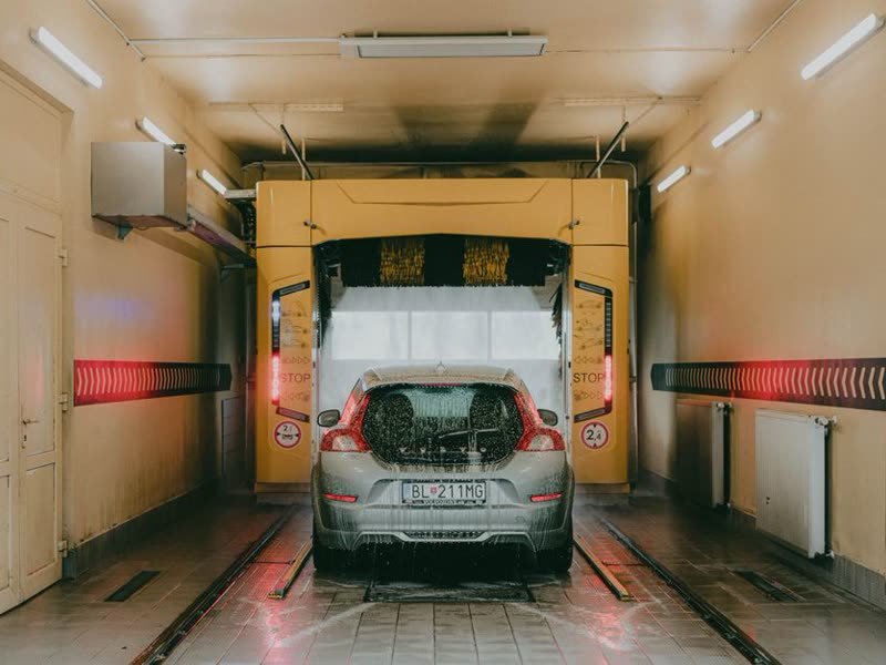 Carro passando pelo túnel de lavagem automática, entre os rolos
